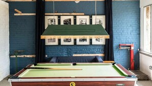 A billiards table in a room with a blue brick wall, framed pictures, and a green ceiling. - 2 Bed in Cranmer (oc-w45791) (Cranmer)