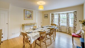 A dining room with a table set for four, wooden chairs, a radiator, a window with curtains, and a ceiling light. - 2 Bed in Newtyle (oc-b45543) (Newtyle)