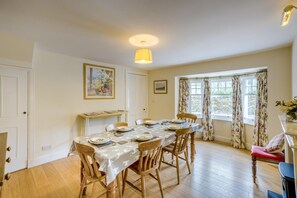 A dining room with a table set for four, wooden chairs, a radiator, a window with curtains, and a ceiling light. - 2 Bed in Newtyle (oc-b45543) (Newtyle)