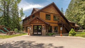 A lodge with a stone foundation, a wooden exterior, and a staircase leading to the upper level. - Escape to Ptarmigan Village 36 (Whitefish)