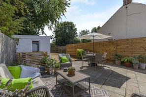 An outdoor patio area with a dining table, chairs, and a large umbrella. - 2 Bed in Great Massingham (oc-a45882) (Great Massingham)