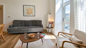 A modern living room with a sofa, a coffee table, and a window with a view. - 2 Bed in Ilfracombe (oc-b45841) (Ilfracombe)