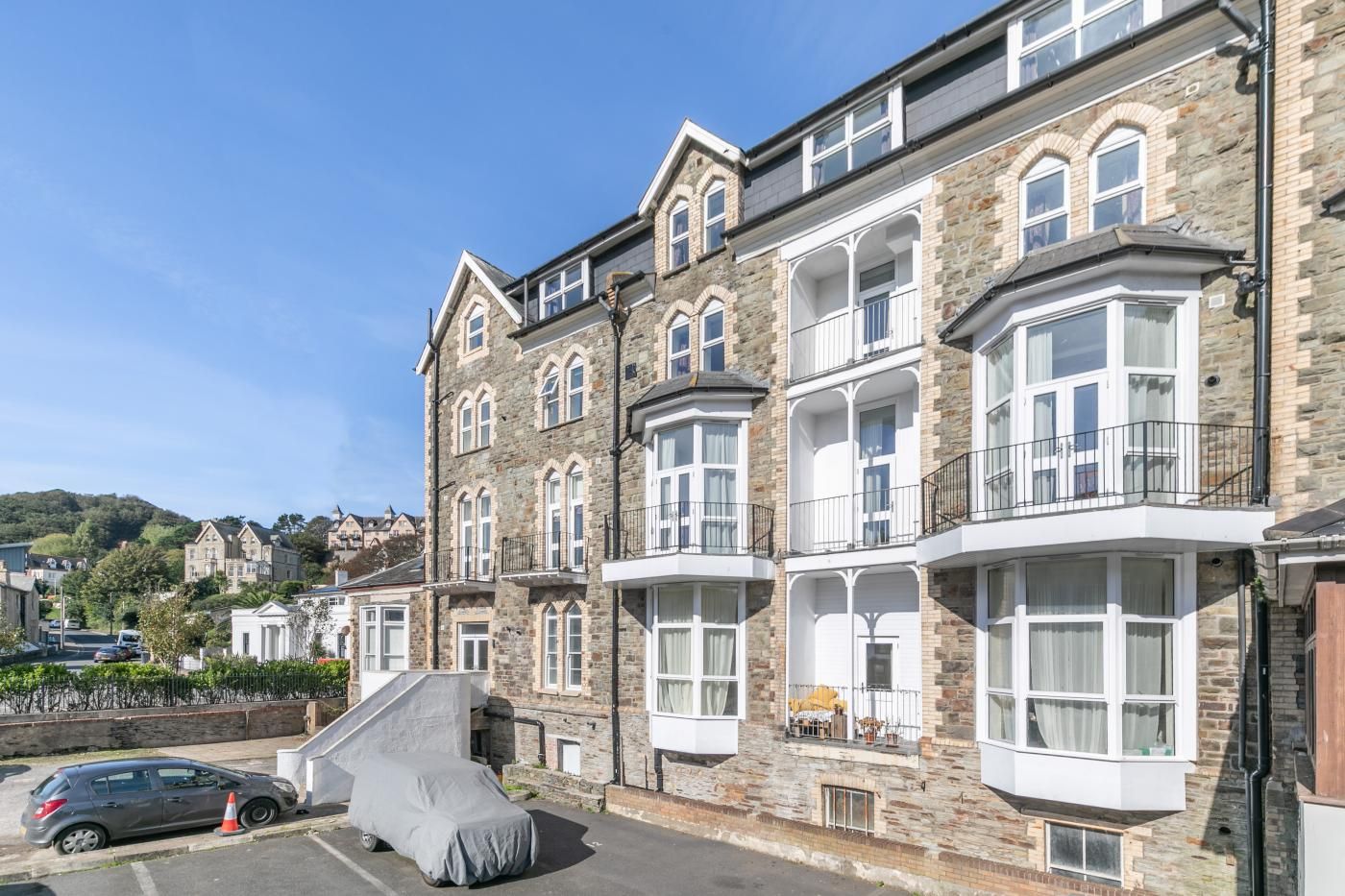 Un immeuble à plusieurs étages, doté d’une façade en pierre, de grandes fenêtres et de balcons.