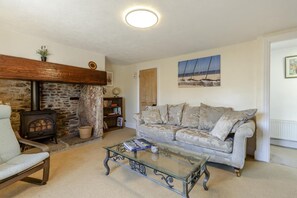 A cozy living room with a stone fireplace, a sofa, a glass coffee table, and a bookshelf. - 2 Bed in Cheddar (oc-v45773) (Cheddar)