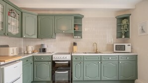 A kitchen with green cabinets, a white refrigerator, a stove, a microwave, and a sink. - 3 Bed in Allendale (oc-b45877) (Allendale Town)