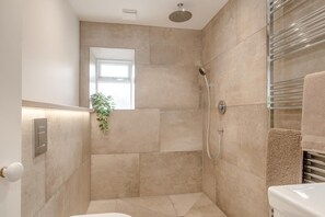 Ein modernes Badezimmer mit Dusche, kleinem Fenster und Handtuchhalter.