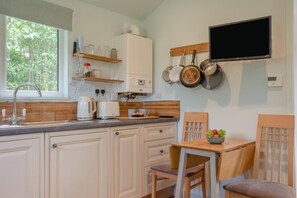 A kitchen with a built-in oven, a coffee maker, a kettle, and a TV mounted on the wall. - 1 Bed in Laddingford (oc-s45858) (Laddingford)