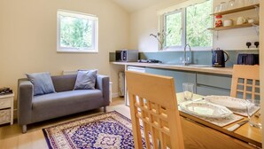 A compact living space with a sofa, dining table, and kitchen area including a microwave and kettle. - 1 Bed in Laddingford (oc-s45859) (Laddingford)