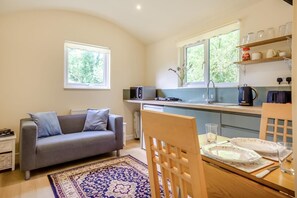 A compact living space with a sofa, dining table, and kitchen area including a microwave and kettle. - 1 Bed in Laddingford (oc-s45859) (Laddingford)