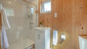 A bathroom with a glass shower enclosure, a white sink, and wooden paneling. - 1 Bed in Laddingford (oc-s45860) (Laddingford)