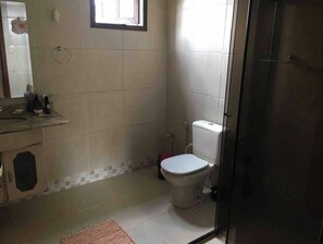 A bathroom with a toilet, a sink, and a mirror. - Our 2-bedroom house, 12 km from Inhotim Brumadinho (Brumadinho)