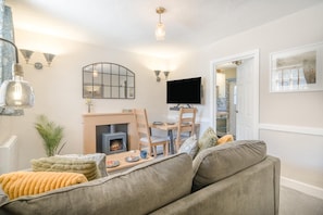 A cozy living room with a fireplace, a flat-screen TV, and a comfortable sofa. - 1 Bed in Grasmere (oc-lr250) (Grasmere)
