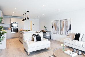 Una sala de estar moderna con un sofá, una mesa de centro y un comedor con mesa y sillas.