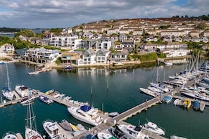 A marina with various boats docked, surrounded by residential buildings. - 2 Bed in Falmouth (oc-b669263) (Flushing)