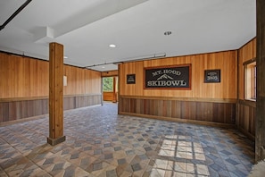 A hallway with wooden paneling, a tiled floor, and signs indicating 'Mt. Hood Skibowl' and 'Lodge 3805.'