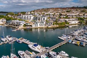 A marina with boats docked, surrounded by residential buildings. - 3 Bed in Falmouth (oc-b673665) (Flushing)