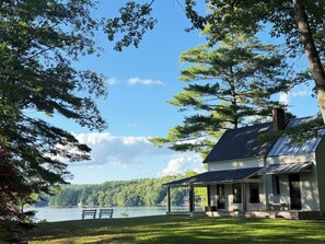 A lakeside house with a covered porch, a grassy lawn, and a bench by the water. - 2 Home Lakefront estate, with 4 bedrooms, 3.5 baths, and 2 acres of private land (Enfield)