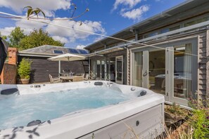 A hot tub with a table and chairs, a covered patio area, and a wooden fence. - 3 Bed in Cranmer (oc-g45793) (Cranmer)