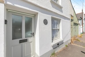 A white house with a front door, a window, and a small porch area. - 2 Bed in Appledore (oc-d45715) (Appledore)