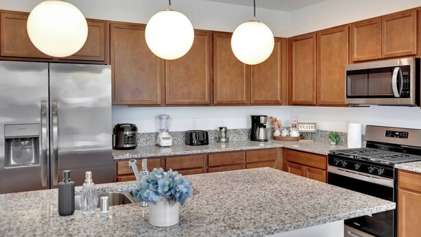 A modern kitchen with granite countertops, stainless steel appliances, wooden cabinets, and pendant lighting. - Modern 5B3B｜Near Strip｜Fiber WiFi｜TV in all Rooms (Las Vegas)
