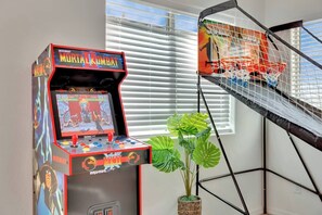 Ein Midway-Spielautomat für Mortal Kombat II, ein Basketballkorb und ein Blumentopf.