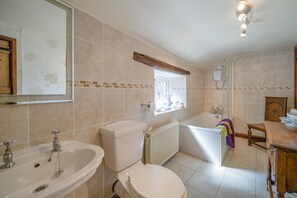 A bathroom with a bathtub, toilet, sink, and a window. - 1 Bed in Ribchester (oc-n45957) (Ribchester)