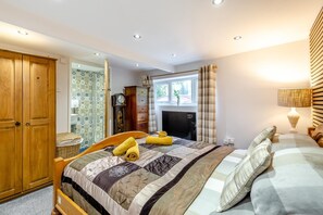 Une chambre à coucher avec un lit, une armoire en bois, une horloge, une cheminée et une fenêtre avec des rideaux.