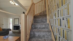 A staircase with a wooden handrail leading to a bookshelf filled with books. - 2 Bed in Crow (oc-h45921) (Ringwood)