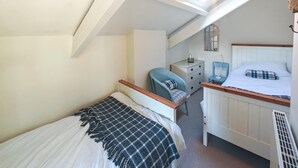 A bedroom with a bed, a chair, a dresser, and a window with a light fixture. - 3 Bed in Treknow (oc-p45966) (Treknow)