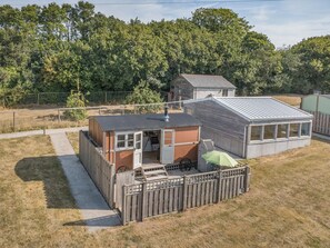 A fenced backyard with a small wooden structure, a metal roof, and a green umbrella. - 1 Bed in St Austell (oc-h45926) (High Street)