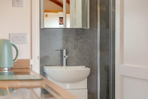 A bathroom with a white sink, a chrome faucet, and a mirror above it. - 1 Bed in St Austell (oc-s45927) (High Street)