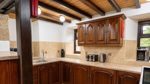 A kitchen with wooden cabinets, a tiled backsplash, and a built-in oven. - 2 Bed in Bolton By Bowland (oc-m45938) (Grindleton)