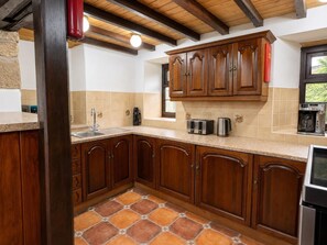A kitchen with wooden cabinets, a tiled backsplash, and a built-in oven. - 2 Bed in Bolton By Bowland (oc-m45938) (Grindleton)