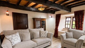 A living room with a sofa and armchairs, wooden beams on the ceiling, and a window with curtains. - 2 Bed in Bolton By Bowland (oc-m45938) (Grindleton)