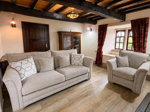 A living room with a sofa and armchairs, wooden beams on the ceiling, and a window with curtains. - 2 Bed in Bolton By Bowland (oc-m45938) (Grindleton)
