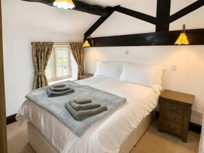 A bedroom with a bed, bedside tables, a window with curtains, and a ceiling with exposed beams. - 2 Bed in Bolton By Bowland (oc-m45938) (Grindleton)