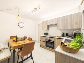 A modern kitchen with wooden cabinets, a built-in oven, and a sink. - 4 Bed in St. Ives (oc-s46007) (Saint Ive)