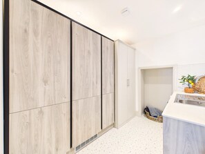 A modern kitchen with white cabinetry, a stainless steel sink, and a small countertop area. - 4 Bed in St. Ives (oc-s46007) (Saint Ive)