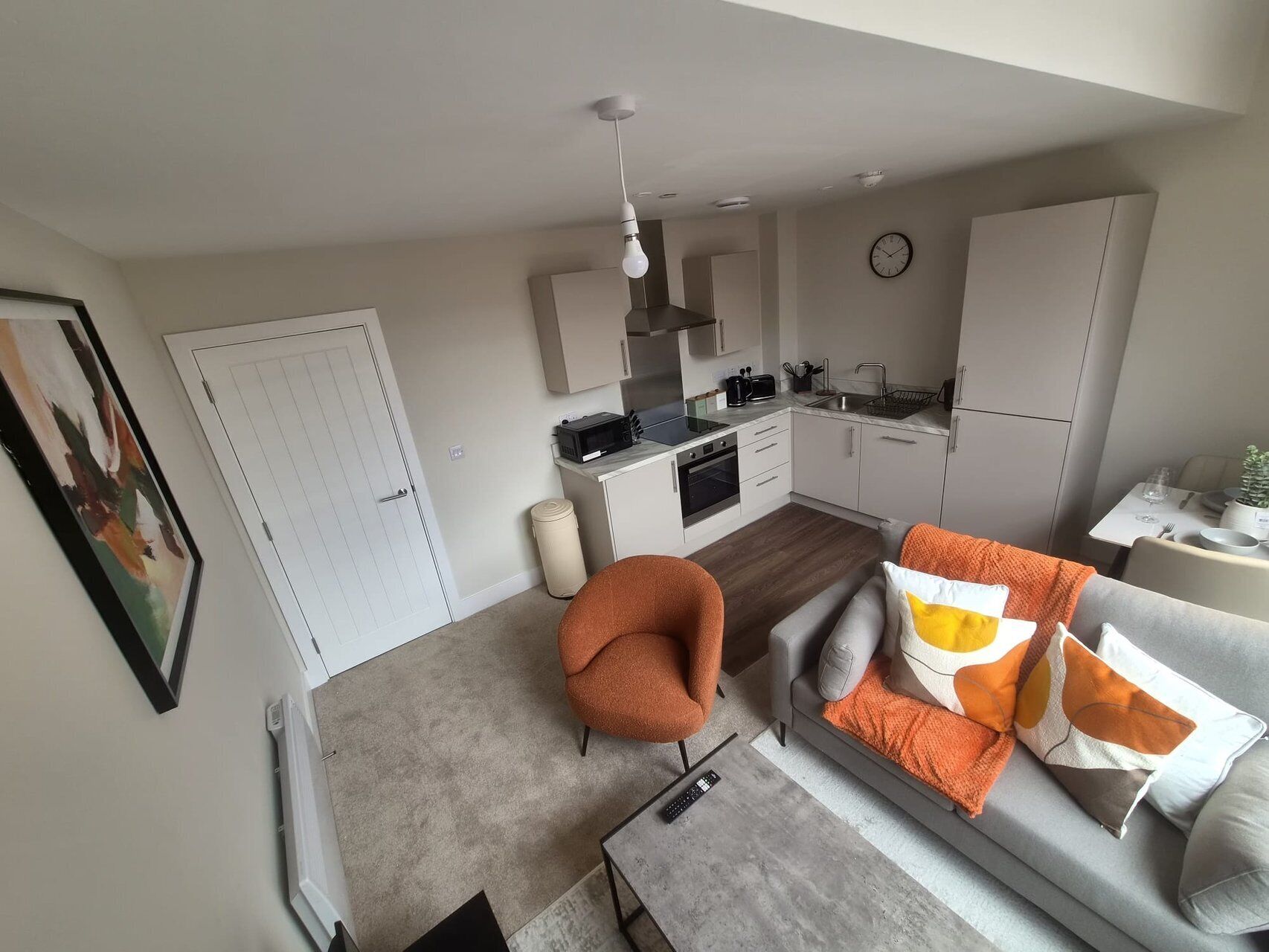 A modern apartment with a kitchen, dining area, and living room.