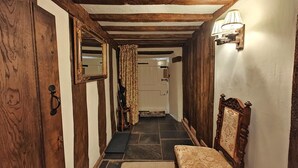 A narrow hallway with wooden beams, a bench, a mirror, and a door. - 2 Bed in Buckerell (oc-h45977) (Buckerell)