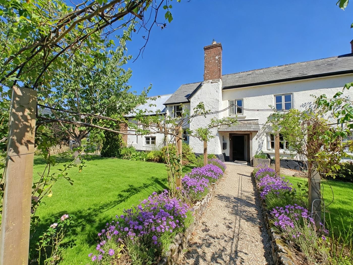 A two-story house with a garden pathway leading to the entrance.