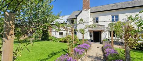 A two-story house with a garden pathway leading to the entrance.