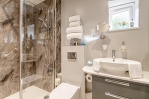 A modern bathroom with a glass-enclosed shower, a white sink with a vanity, and a mirror above the sink. - 1 Bed in Challock (oc-o45948) (Challock)