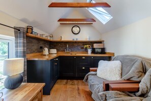 A cozy kitchen with dark cabinets, a wooden countertop, and a skylight above. - 1 Bed in Botus Fleming (oc-f45947) (Botusfleming)