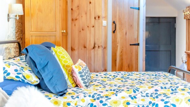 A bedroom with a bed, wooden wardrobe, and a door. - 1 Bed in Botus Fleming (oc-f45947) (Botusfleming)