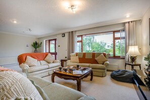 A well-lit living room with two sofas, a coffee table, and a lamp. - 3 Bed in Christchurch (oc-m45917) (Christchurch)