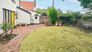 A residential property with a paved patio, a grassy yard, and a brick wall. - 2 Bed in Hoxne (oc-b45969) (Hoxne)