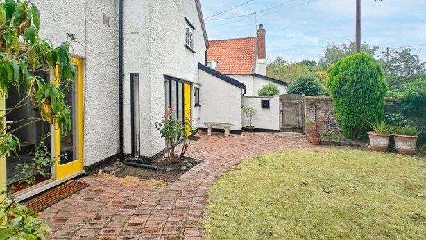 A white building with a red-tiled roof, a brick pathway, and a well-maintained lawn. - 2 Bed in Hoxne (oc-b45969) (Hoxne)