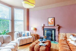 Ein Wohnzimmer mit Kamin, zwei Sofas, einem Couchtisch und einer Lampe.