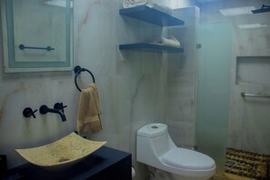A bathroom with a sink, toilet, towel rack, and shelves. - Las Playas Hotel Boutique (Acapulco)